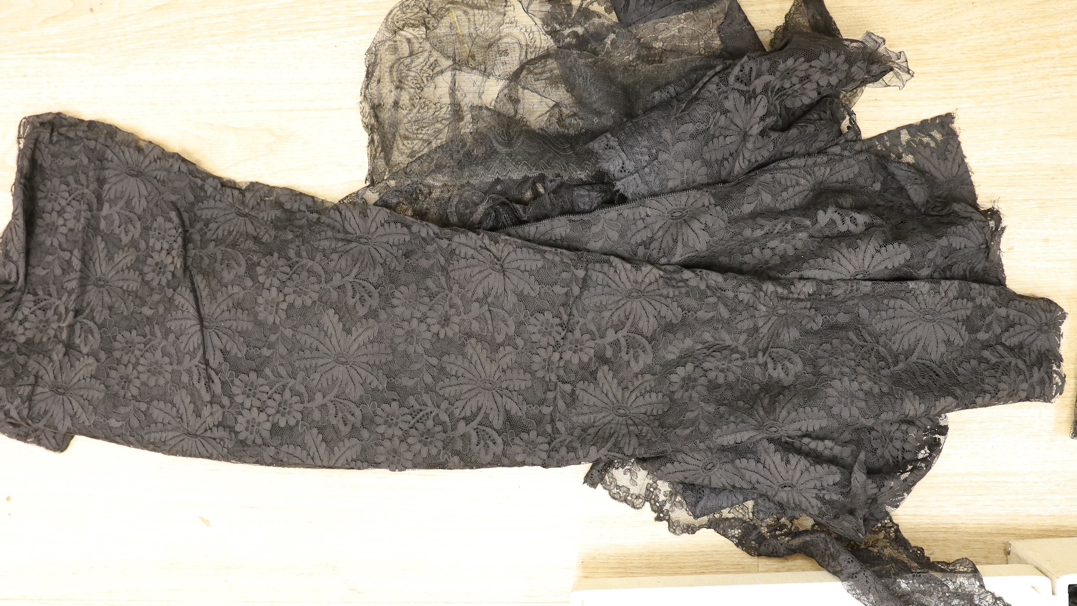 A suitcase of mixed 19th and 20th century black machine and bobbin laces, servants bonnets, cream lace, etc